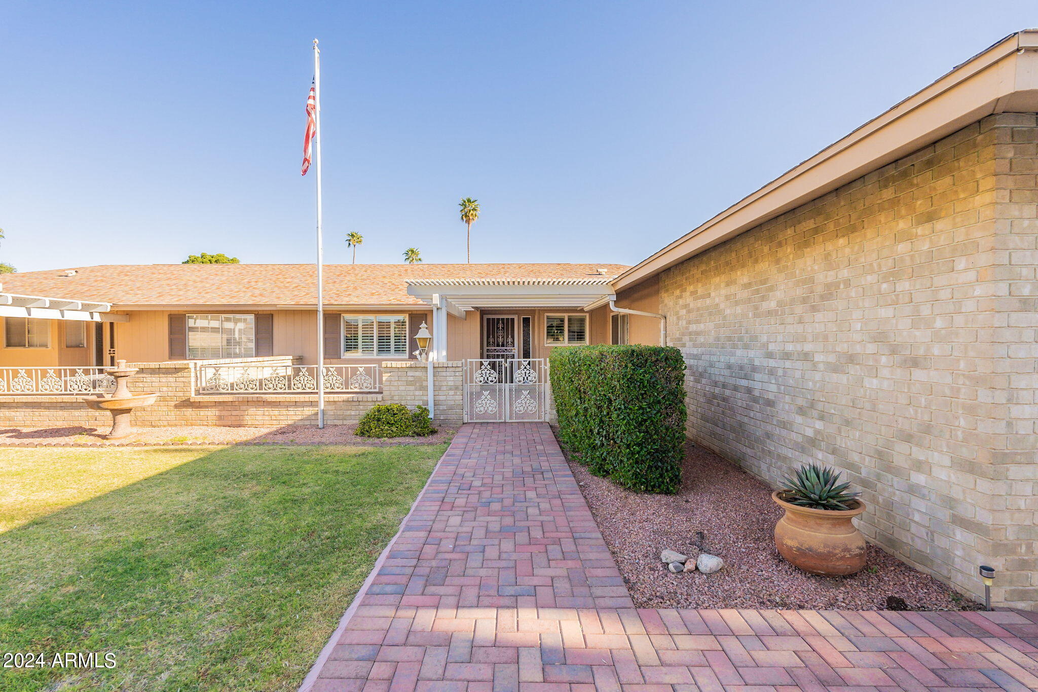 9510 West Greenway Road Sun City, AZ 85351 - Photo 2 of 46 a front view of a house with garden