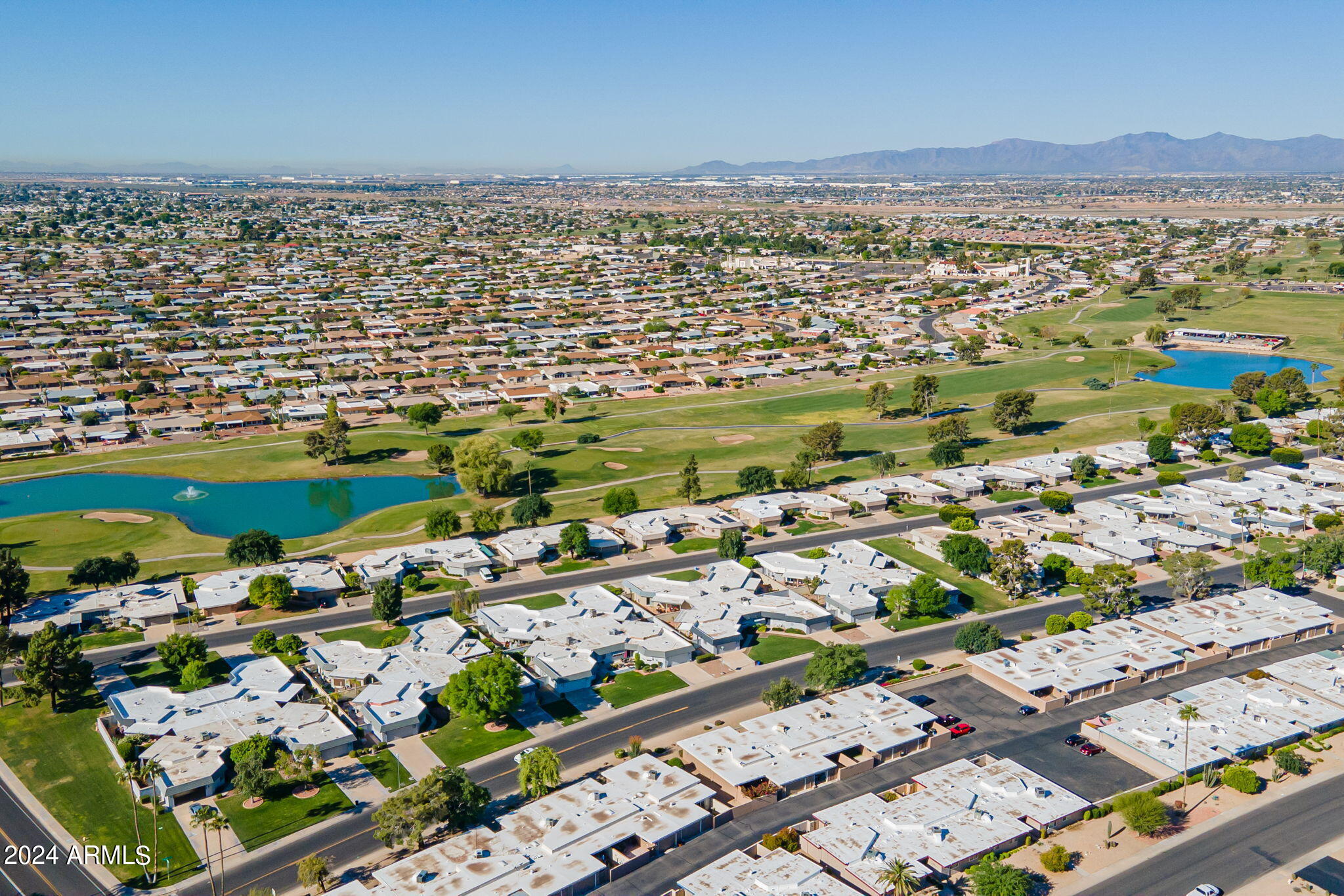 9510 West Greenway Road Sun City, AZ 85351 - Photo 43 of 46 an aerial view of a city with lots of residential buildings and mountain view in back