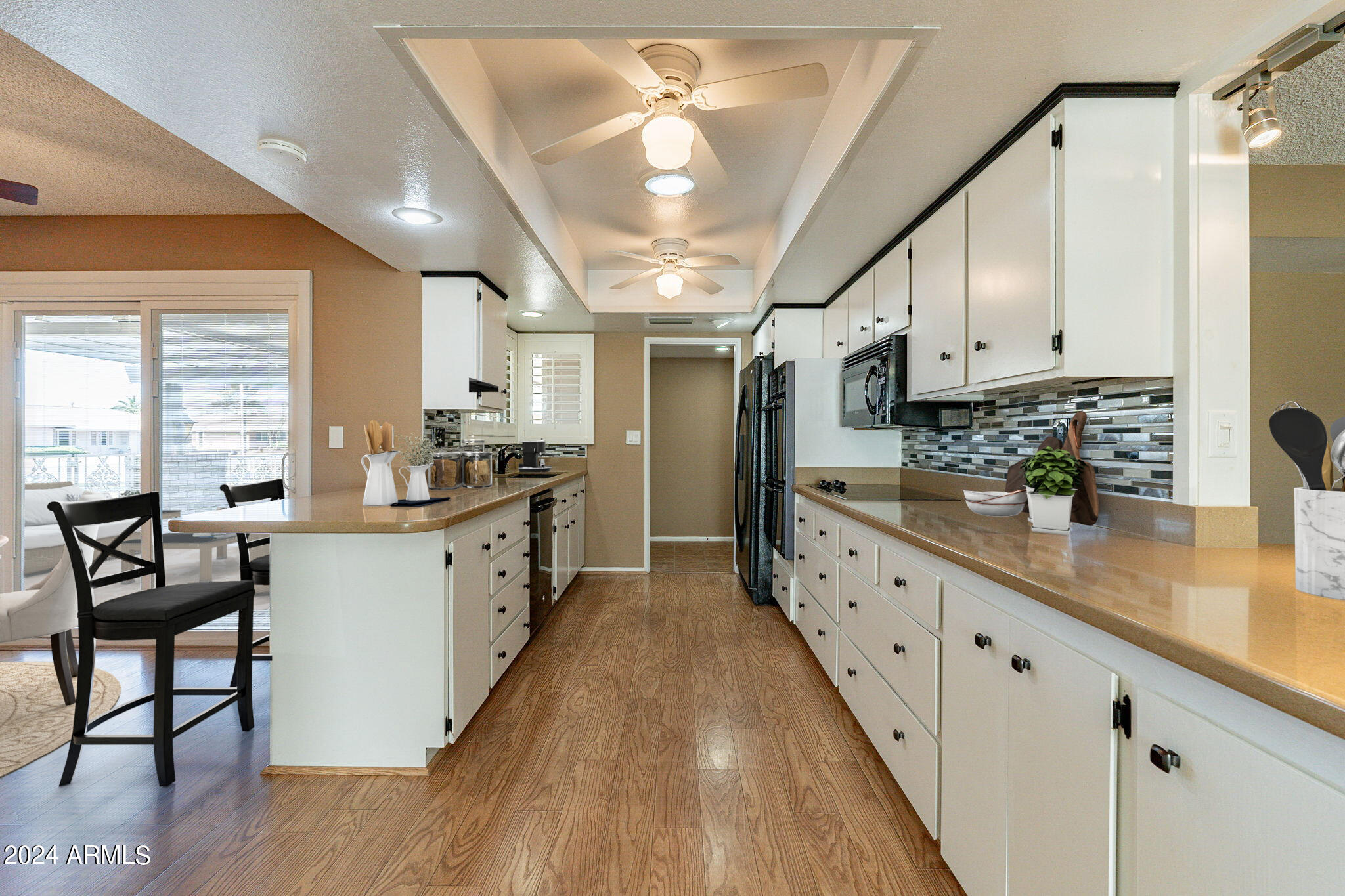 9510 West Greenway Road Sun City, AZ 85351 - Photo 6 of 46 a large kitchen with cabinets wooden floor and stainless steel appliances