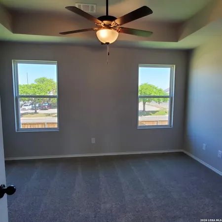 an empty room with a window and a fan