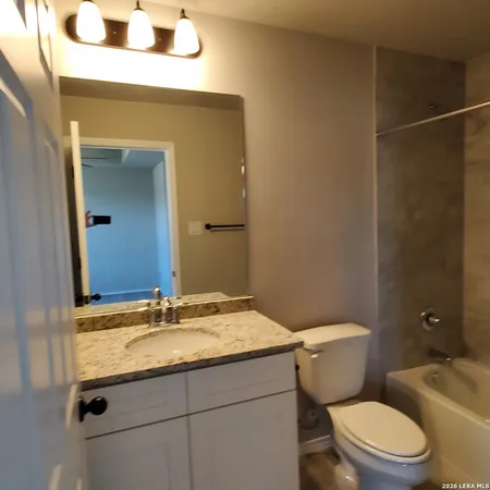 a bathroom with a sink a toilet a mirror and vanity