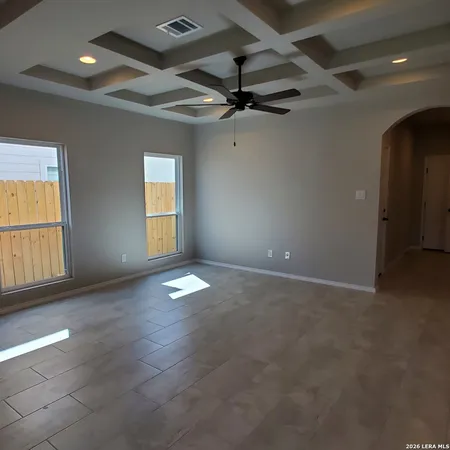 en empty room with windows and ceiling fan