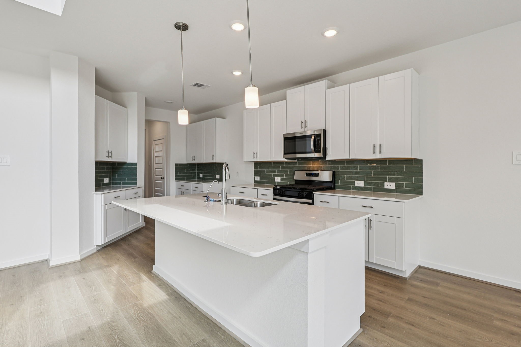 5815 Chamberlain Crossing Rosenberg, TX 77471 - Photo 2 of 35 a kitchen with kitchen island a white counter top space cabinets and stainless steel appliances