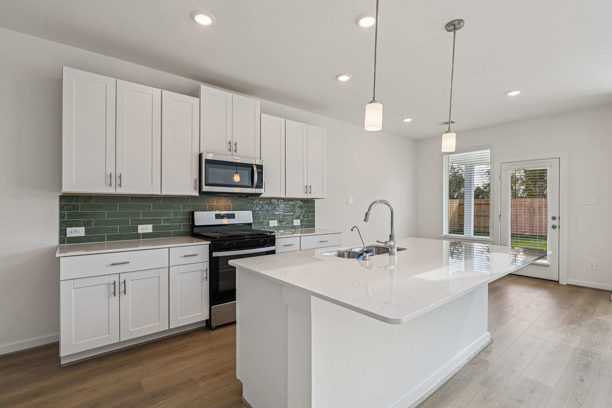 5815 Chamberlain Crossing Rosenberg, TX 77471 - Photo 3 of 35 a kitchen with kitchen island a sink stainless steel appliances and white cabinets