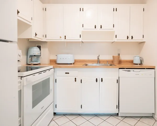 a kitchen with stainless steel appliances white cabinets and white appliances