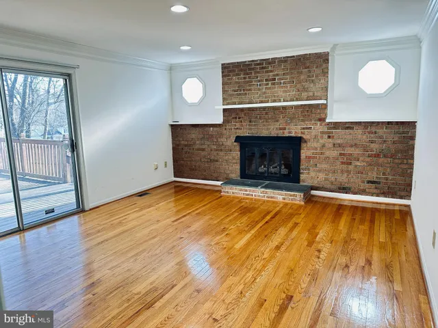 an empty room with wooden floor and fireplace