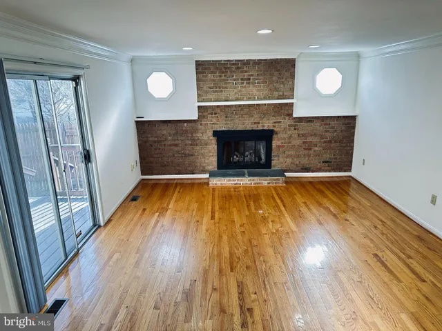 a view of a livingroom with wooden floor and a fireplace