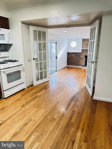 a view of empty room with wooden floor and fireplace