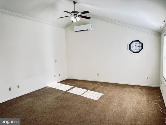 an empty room with a window and a ceiling fan