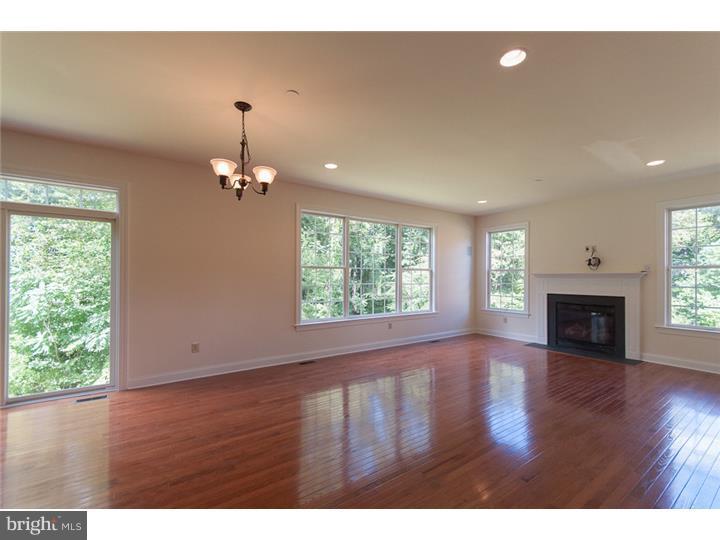 117 North Hillcrest Road Springfield, PA 19064 - Photo 3 of 17 an empty room with wooden floor fireplace and windows