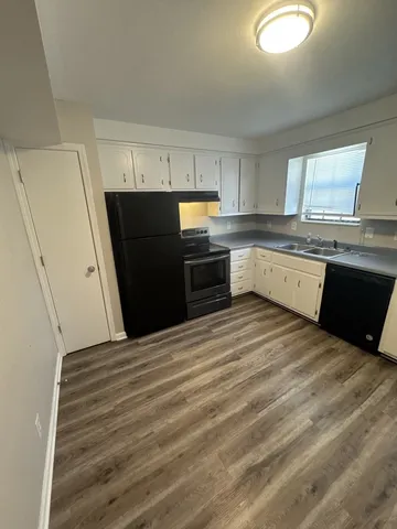 a kitchen with a sink a stove top oven and refrigerator