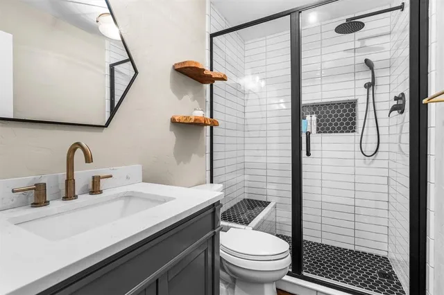 a bathroom with a sink a toilet and shower