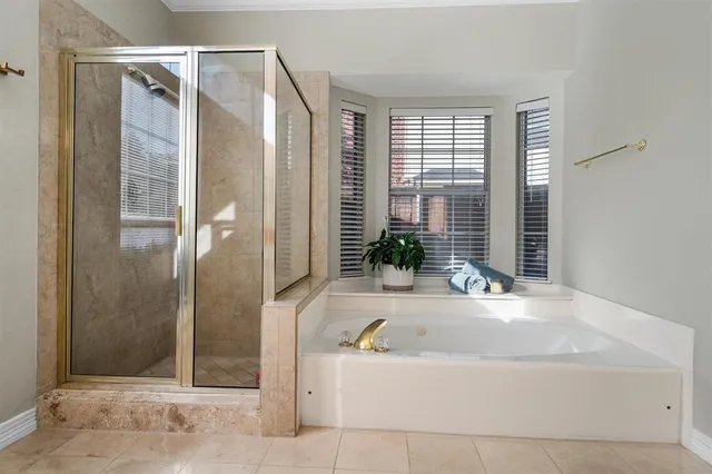 a bathroom with a tub shower and windows
