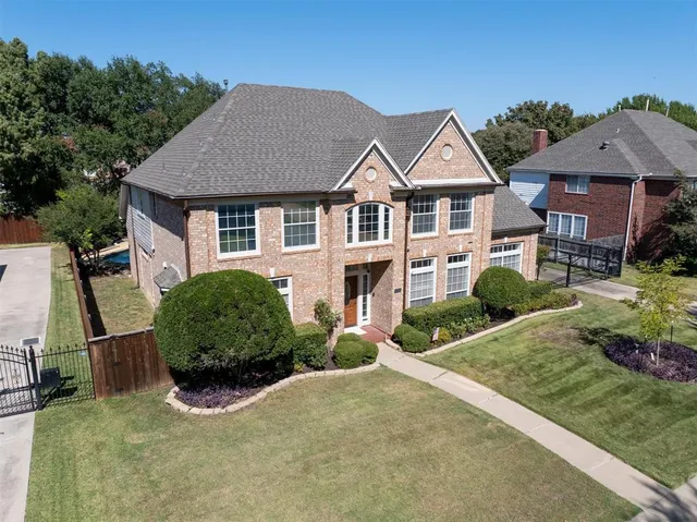 a view of a big house with wooden fence