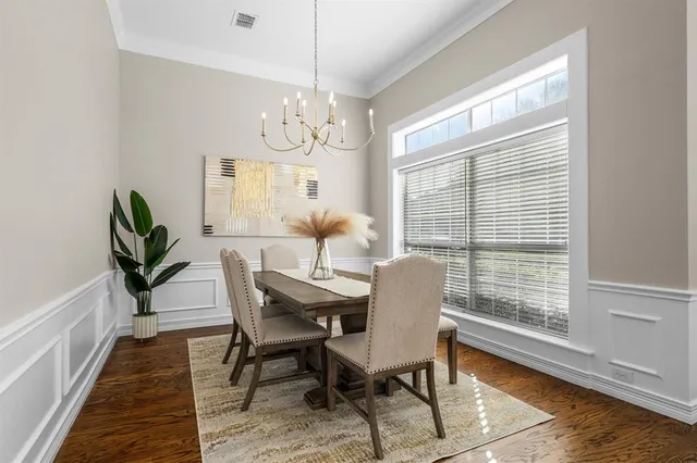 a dining room with furniture a chandelier and wooden floor