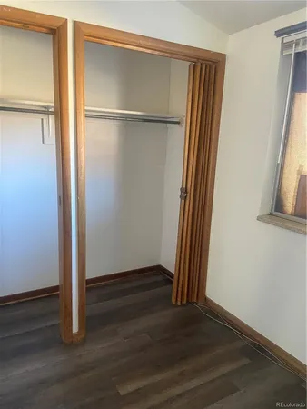 an empty room with wooden floor and a window