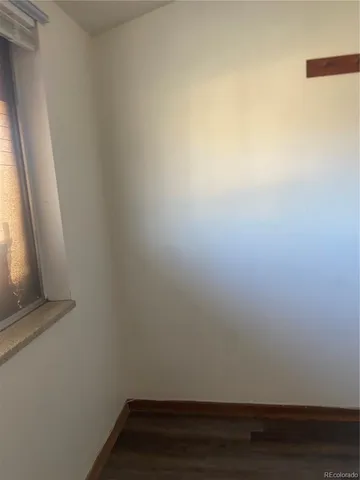 a view of small space with wooden floor and a window