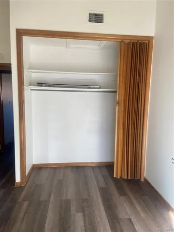 a view of a small space with wooden floor and a window