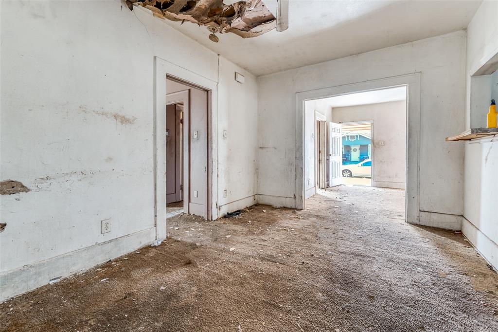 3914 Spence Street Dallas, TX 75215 - Photo 9 of 14 en empty room with a mirror and a ceiling fan