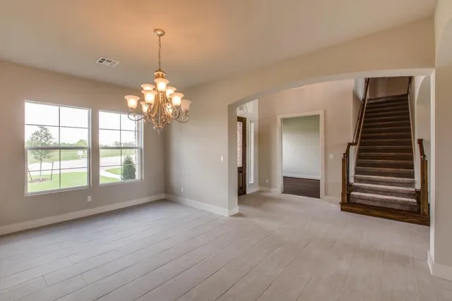 an empty room with windows and stairs