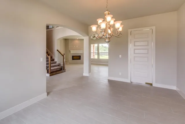 a view of a livingroom with a chandelier fan and windows