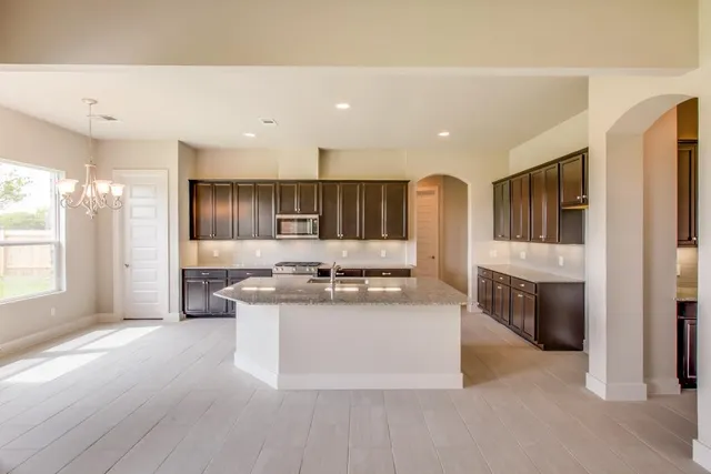 a large kitchen with stainless steel appliances kitchen island granite countertop a large counter top and stove