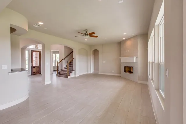 an empty room with fireplace and windows