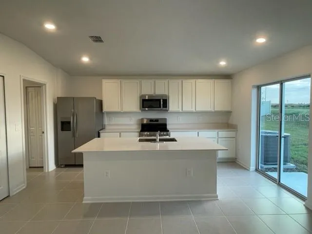 a kitchen with a stove a refrigerator and a sink