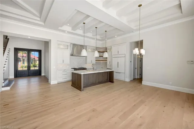 a large kitchen with cabinets wooden floor and stainless steel appliances