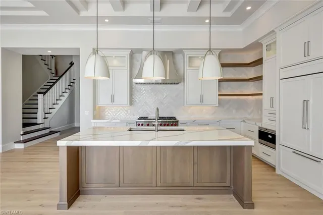 a kitchen with a sink dishwasher and a stove with wooden floor