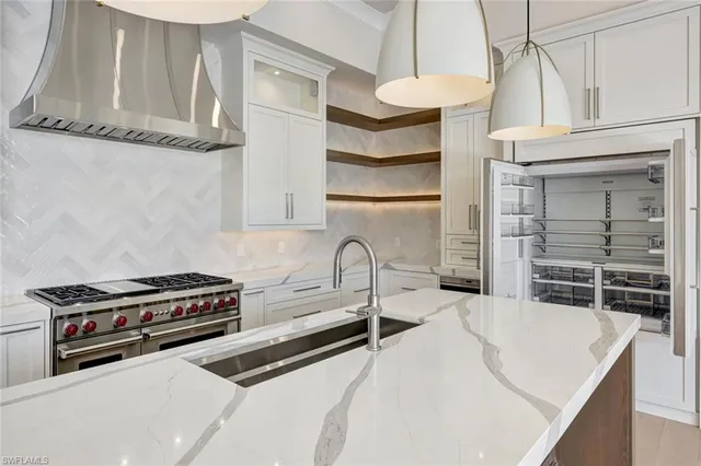 a kitchen with stainless steel appliances a stove a sink and cabinets