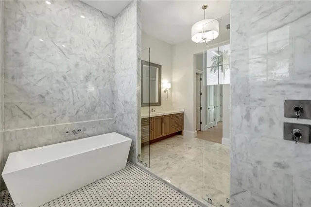 a bathroom with a tub a sink and a shower