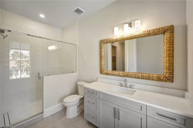 a bathroom with a toilet a sink and mirror