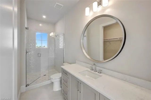 a bathroom with a granite countertop toilet a sink and a mirror