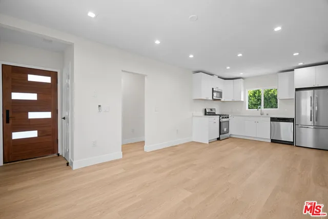 a view of kitchen with stainless steel appliances refrigerator oven stove microwave and cabinets