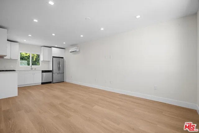 a view of an empty room with a kitchen