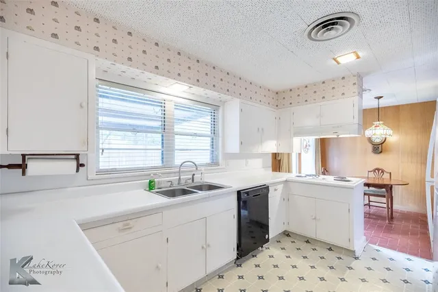 a kitchen with a sink a stove a refrigerator and cabinets