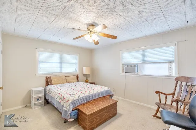 a bedroom with a bed a chair and potted plant
