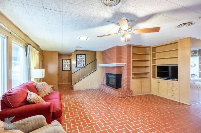 a living room with furniture a fireplace and a flat screen tv