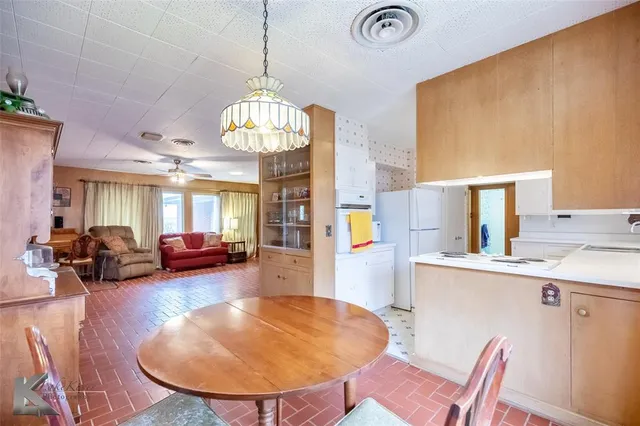 a view of a dining room with furniture a chandelier and wooden floor