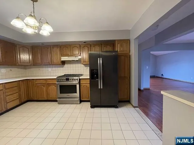 a kitchen with stainless steel appliances granite countertop a refrigerator and a sink