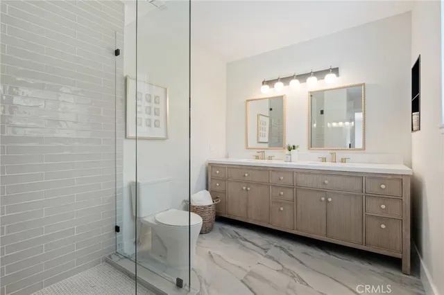 a spacious bathroom with a double vanity sink a large mirror and a shower
