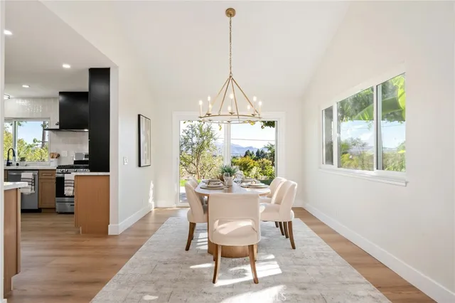 a dining room with furniture a chandelier and wooden floor