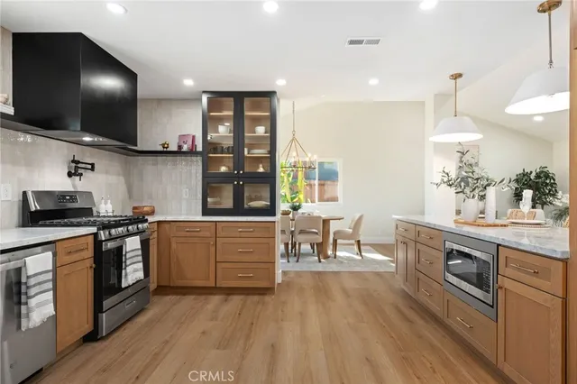 a kitchen with stainless steel appliances granite countertop a stove and a wooden floors