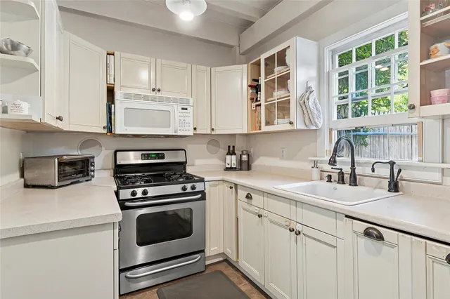 a kitchen with stainless steel appliances a stove a sink and cabinets