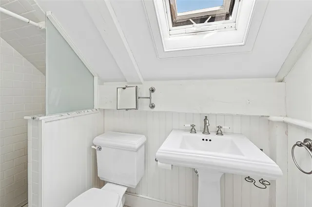 a bathroom with a sink a toilet and mirror