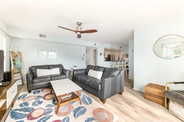 a living room with furniture and a wooden floor