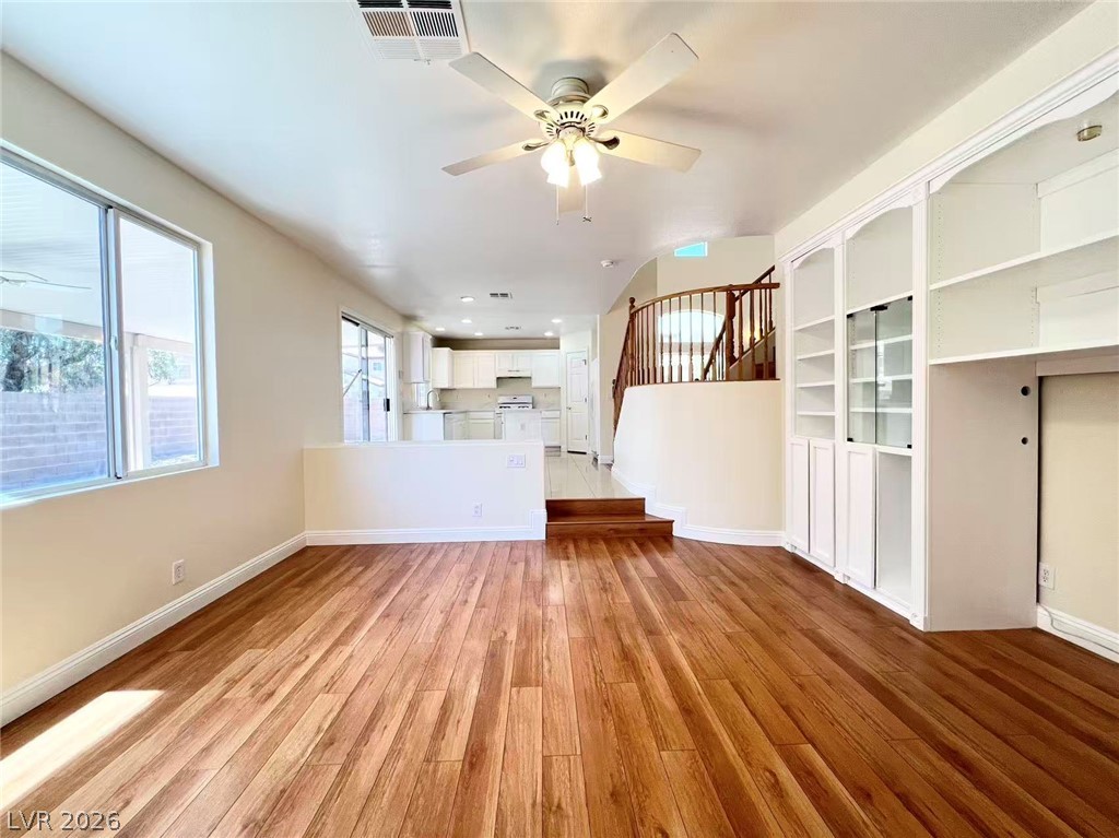 9891 Ridge Hill Avenue Las Vegas, NV 89147 - Photo 11 of 29 A well-lit interior space with gleaming hardwood flooring and built-in shelving, ready for personalization.