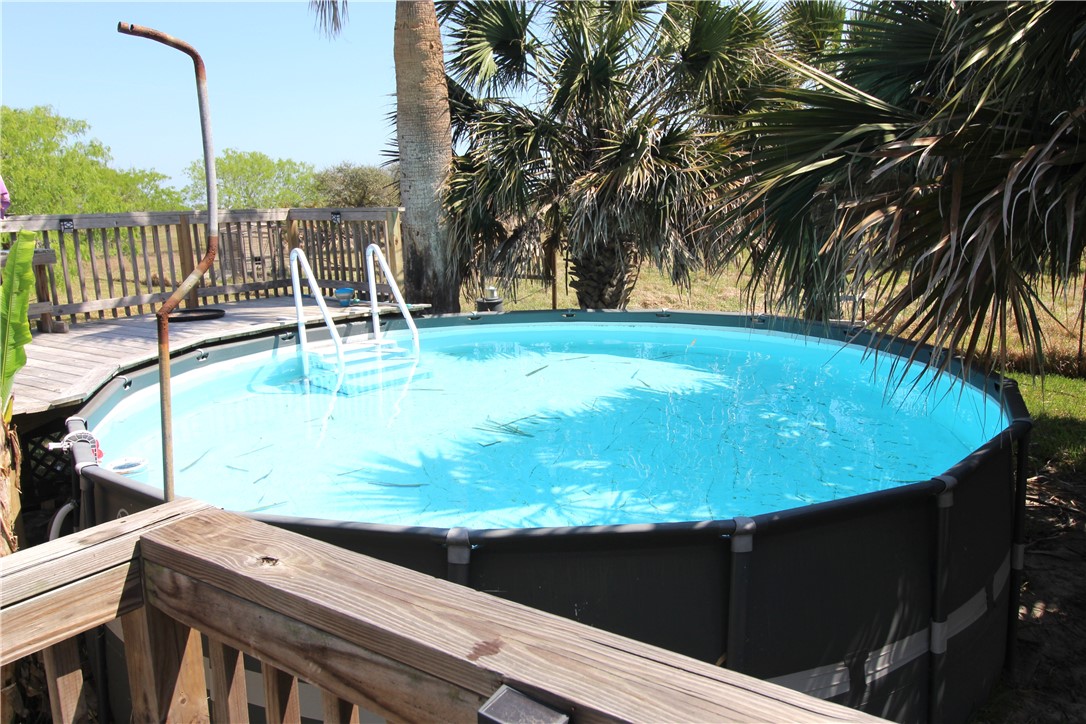 118 Salt Lake Road Rockport, TX 78382 - Photo 11 of 34 a view of a swimming pool with a chair and palm trees