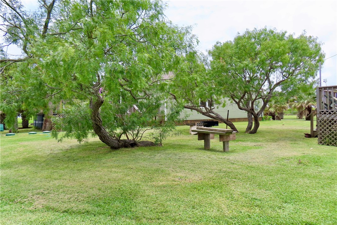 118 Salt Lake Road Rockport, TX 78382 - Photo 16 of 34 a view of a garden with a bench and trees